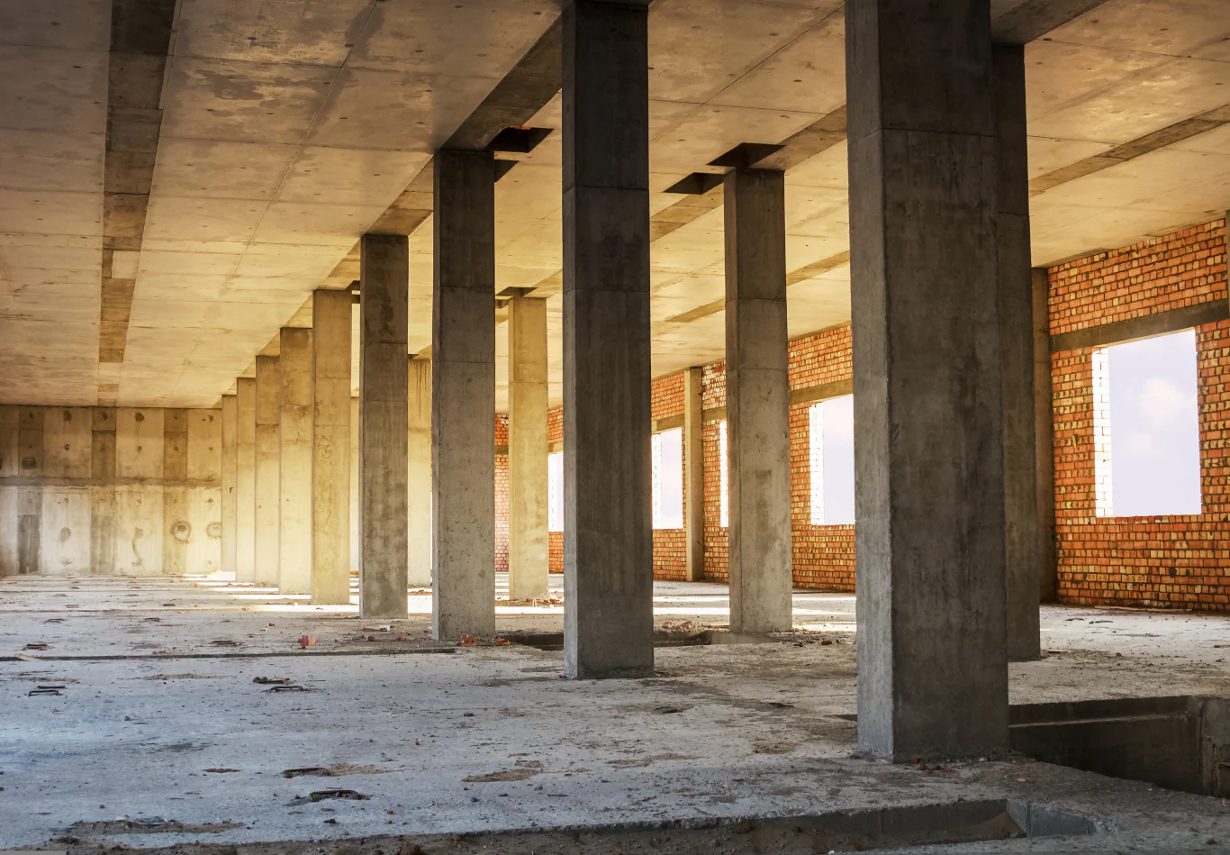 Estrutura de um prédio em construção mostrando pilares de concreto e alvenaria.